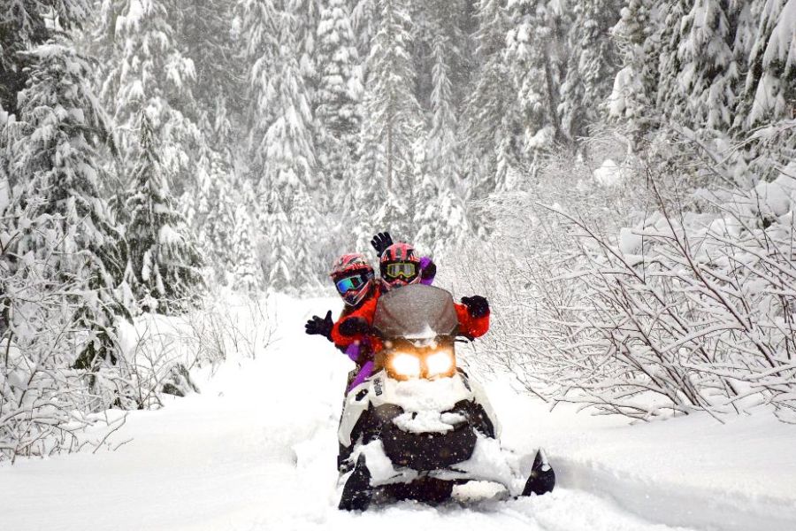 Twee mensen op een sneeuwscooter bij Whistler in Canada.