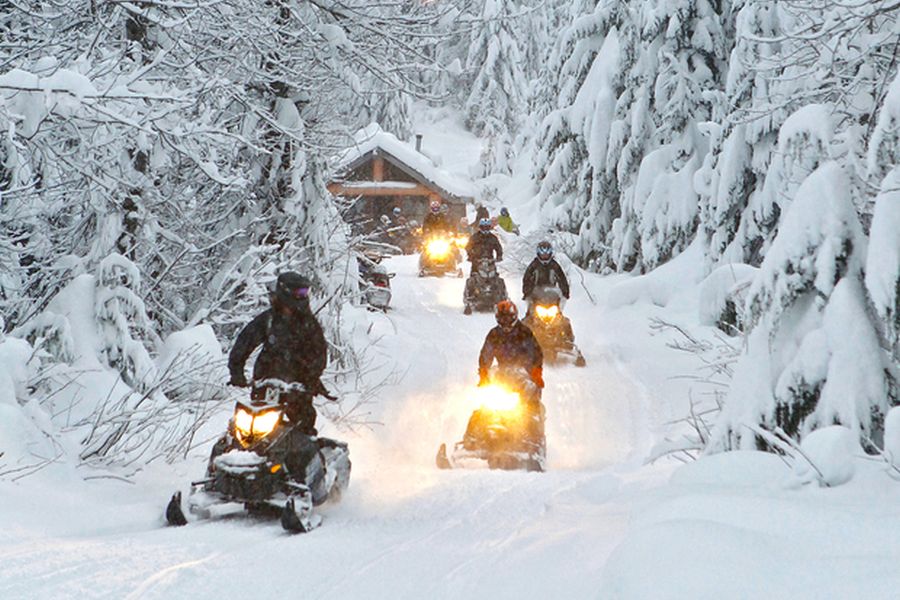 Sneeuwscooters in de besneeuwde bossen van Whistler in British Columbia in Canada.
