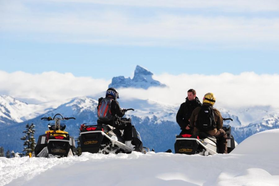 Mensen en sneeuwscooters in de sneeuw in West-Canada.