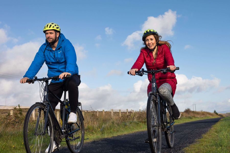 Twee volwassenen al fietsend over de weg in Westport